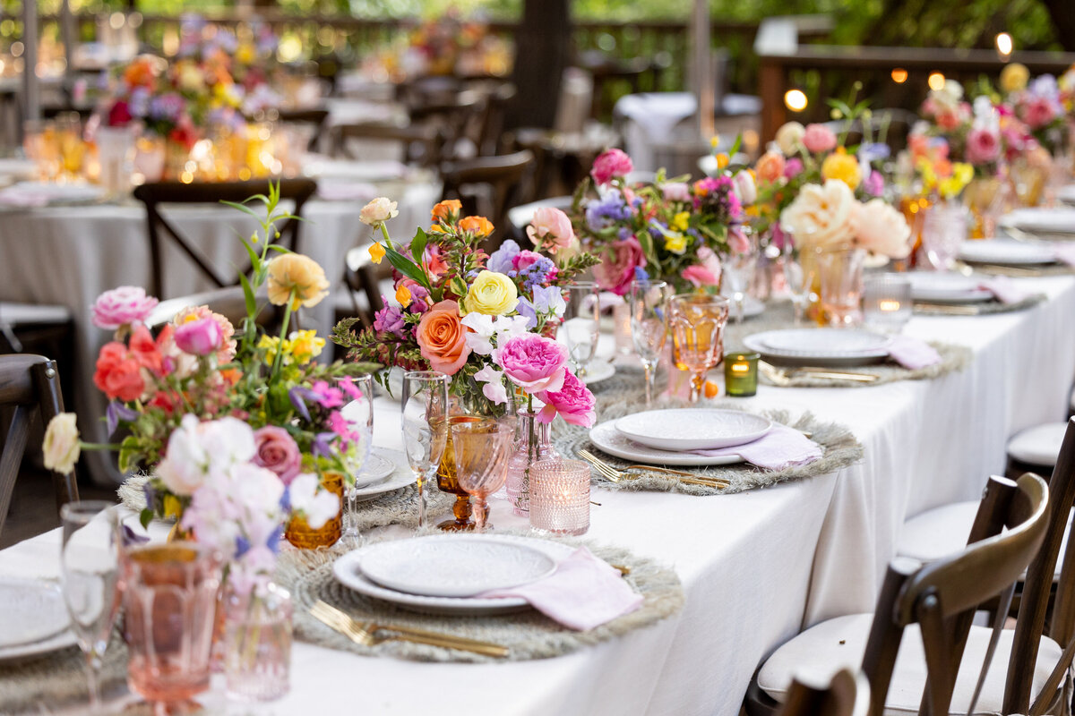 A long wedding reception table decorated with floral arrangements