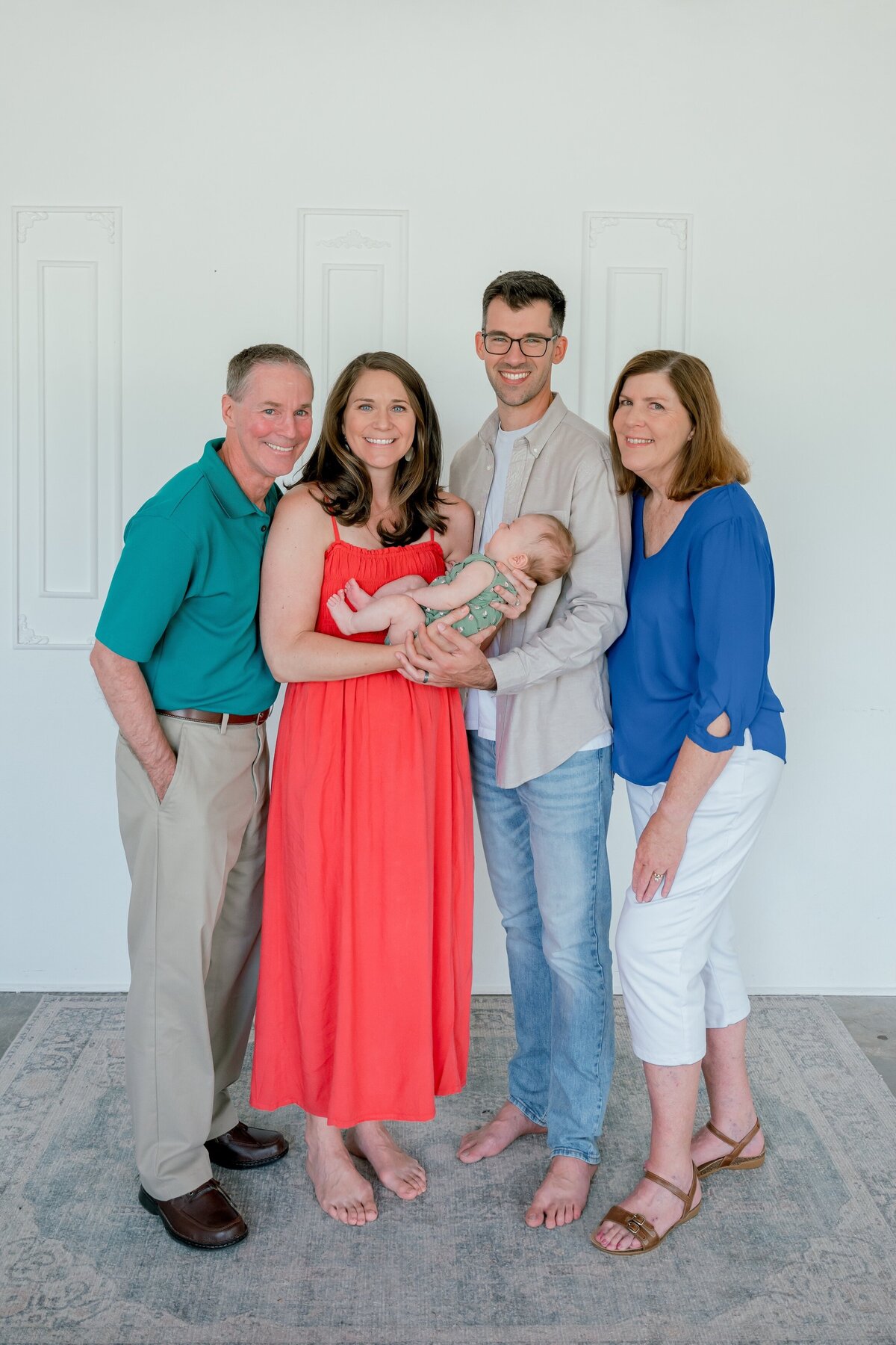 family in studio all smiling at the camera 