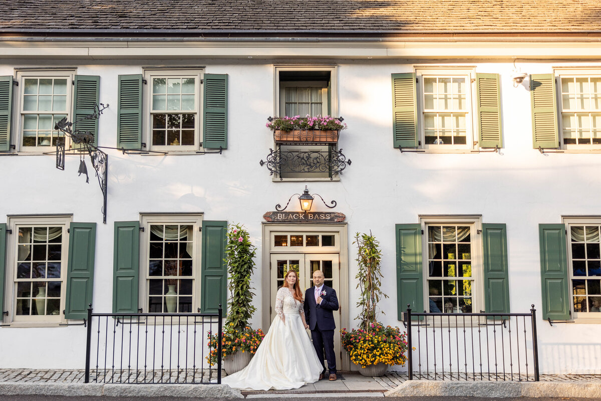 couple posed in front of the black bass hotel in lumberville pa wedding photography by good omen photo co