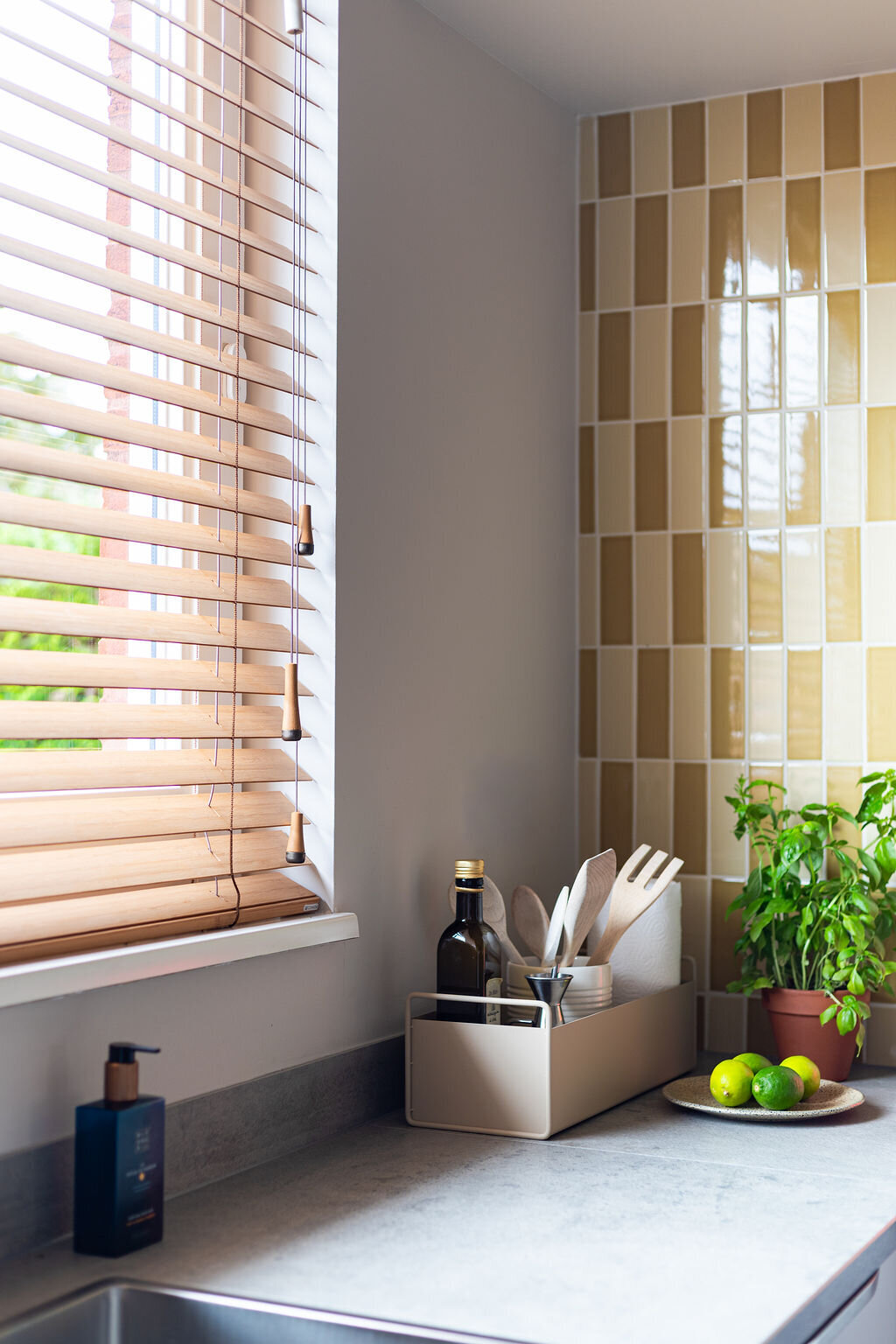 okergele wandtegels keuken en houten jaloezieën