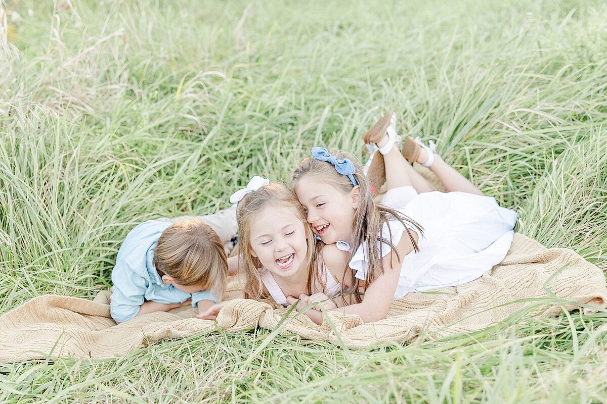 kids laugh on blanket duirng fall family photo session with Sara Sniderman Photography in Natick Massachusetts