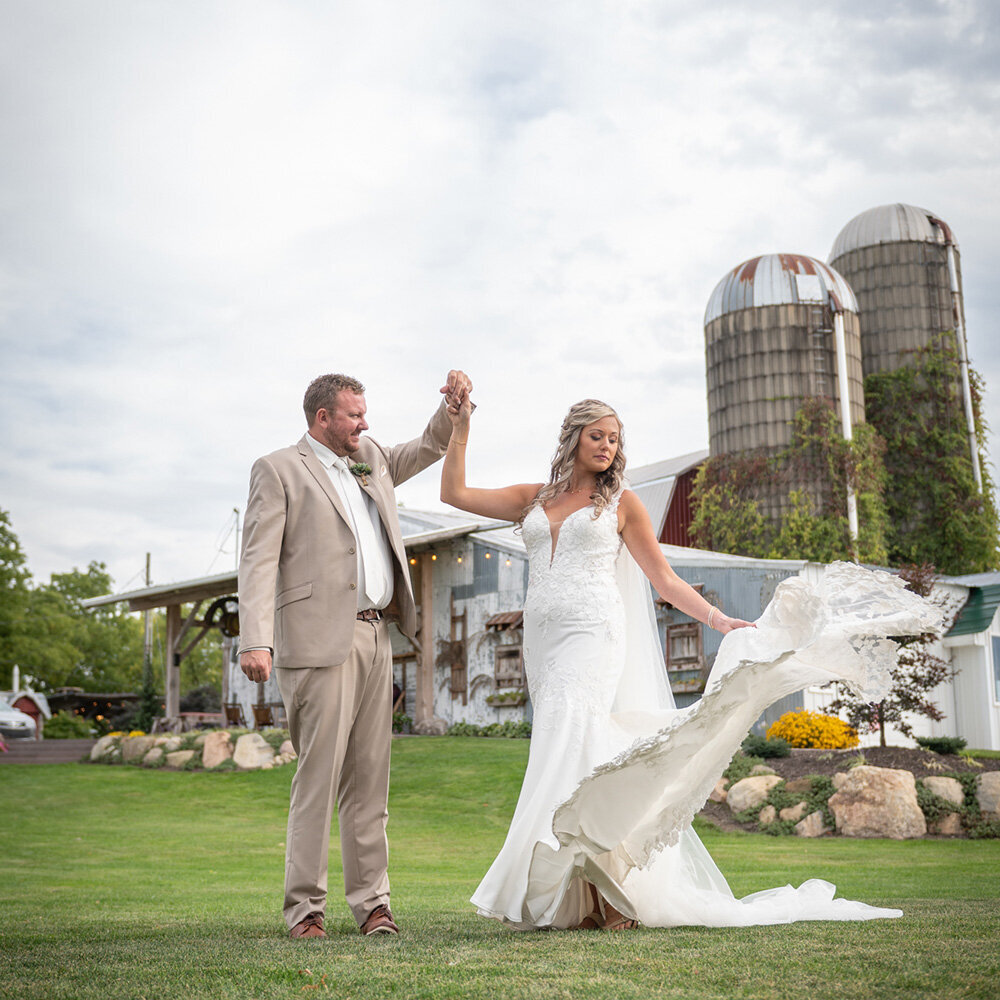 bride and groom smile at each other in front of vines on a silo