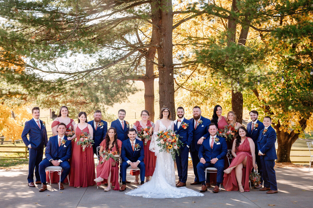 wedding party in burnt orange and navy blue with colorful flowers in autumn