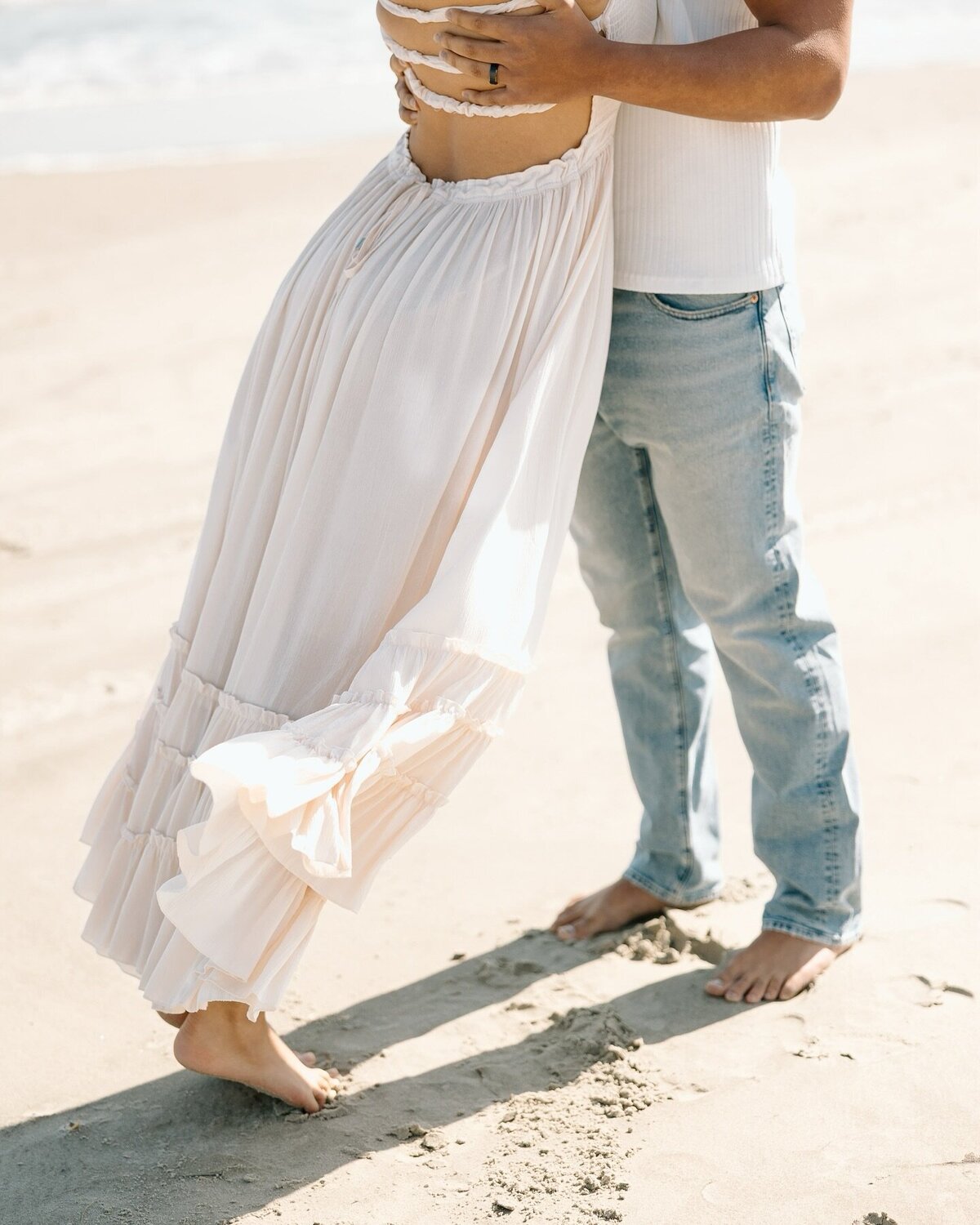 Close-up of a barefoot couple on the beach during a soft, romantic Charleston couples session.