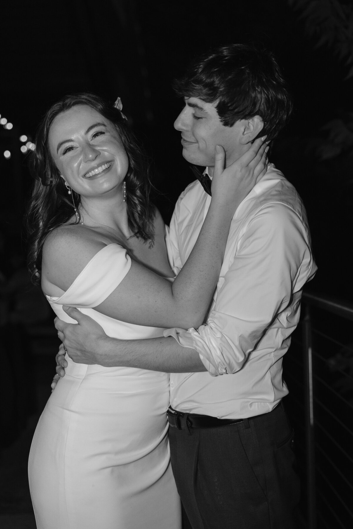 bride and groom pose in black and white photo at their austin reception