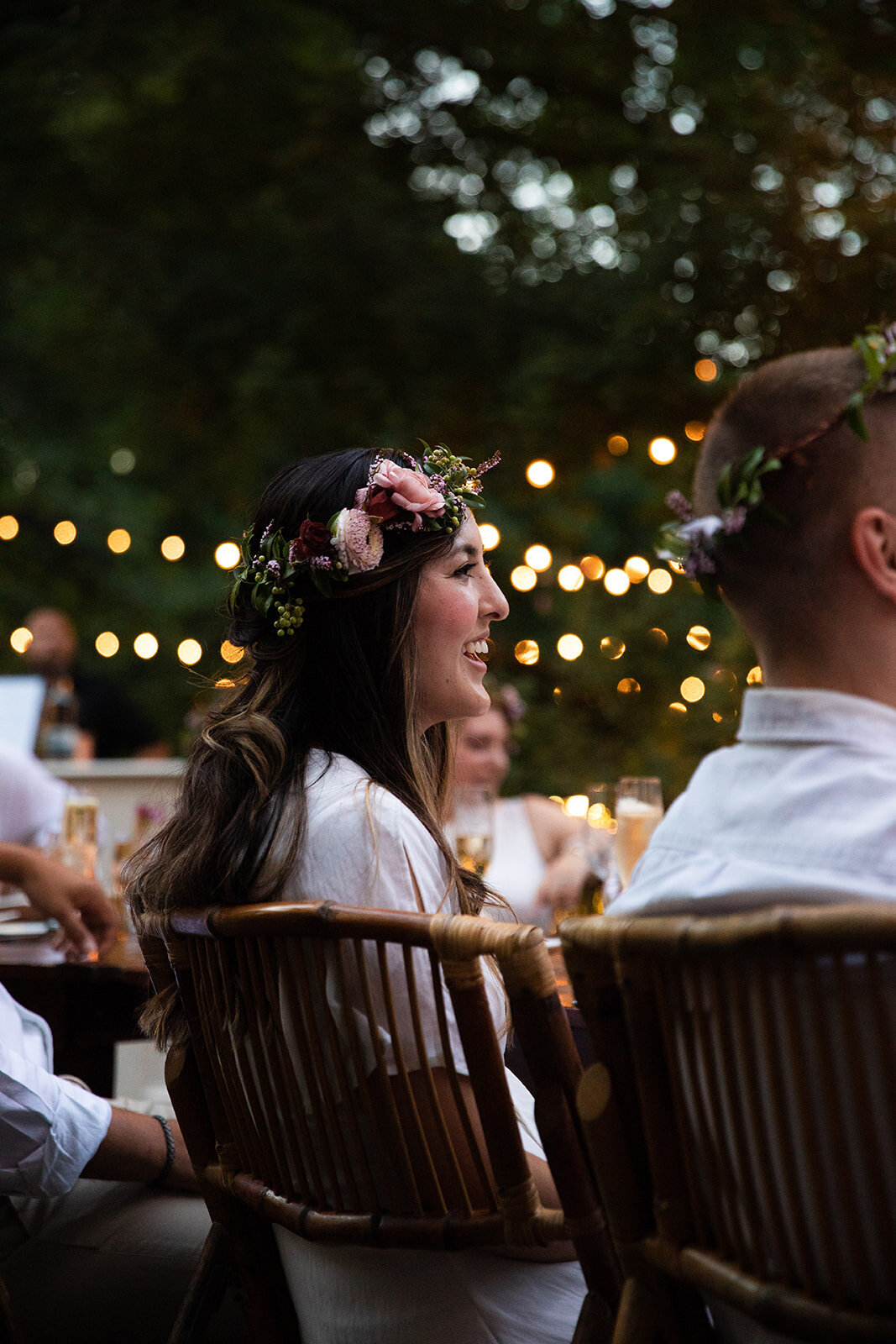 White linen welcome dinner with flower crown for every guest. Wildflower crown booth by Rosemary & Finch, RT Lodge and Nashville luxury wedding florist.