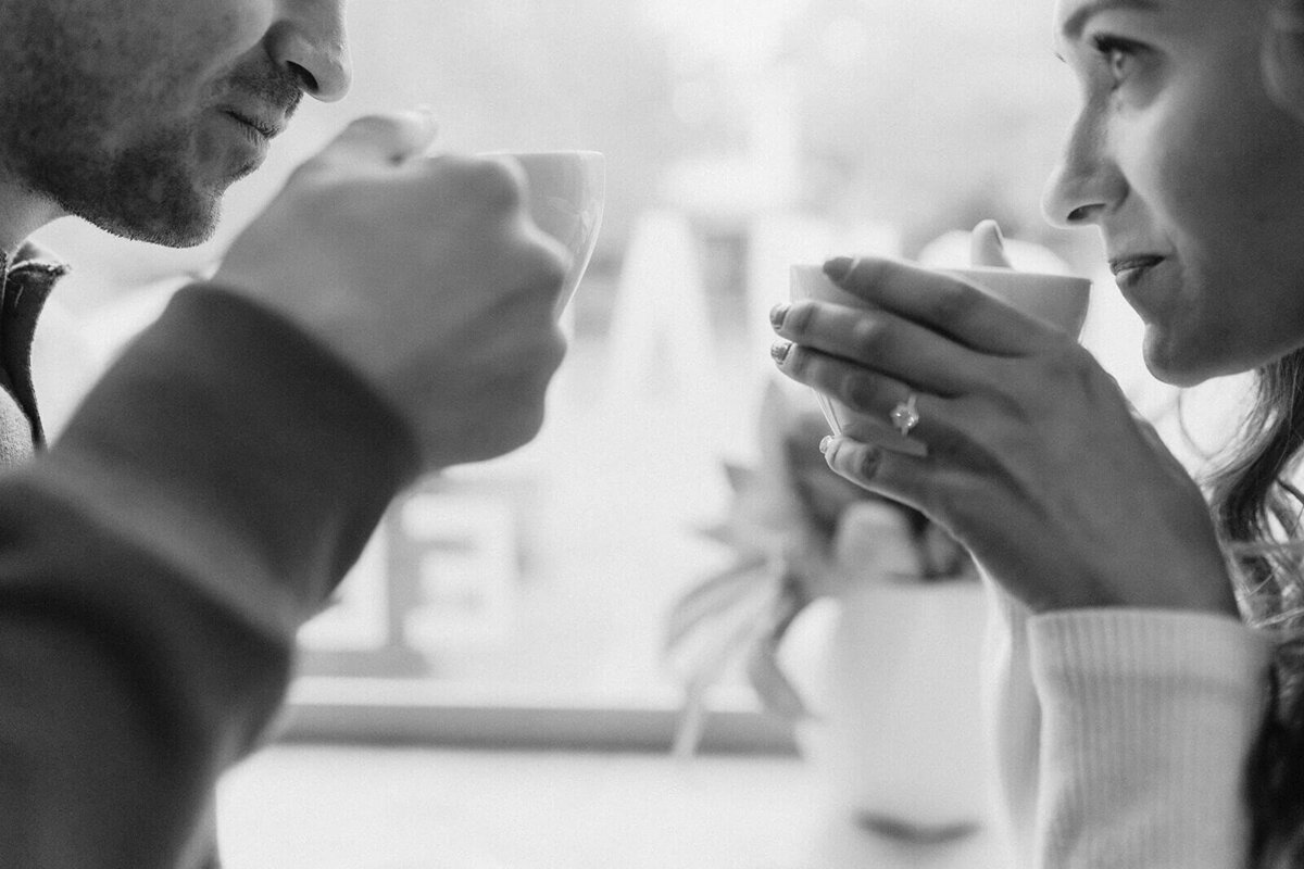 Man and woman sitting opposite each other with coffee in hand