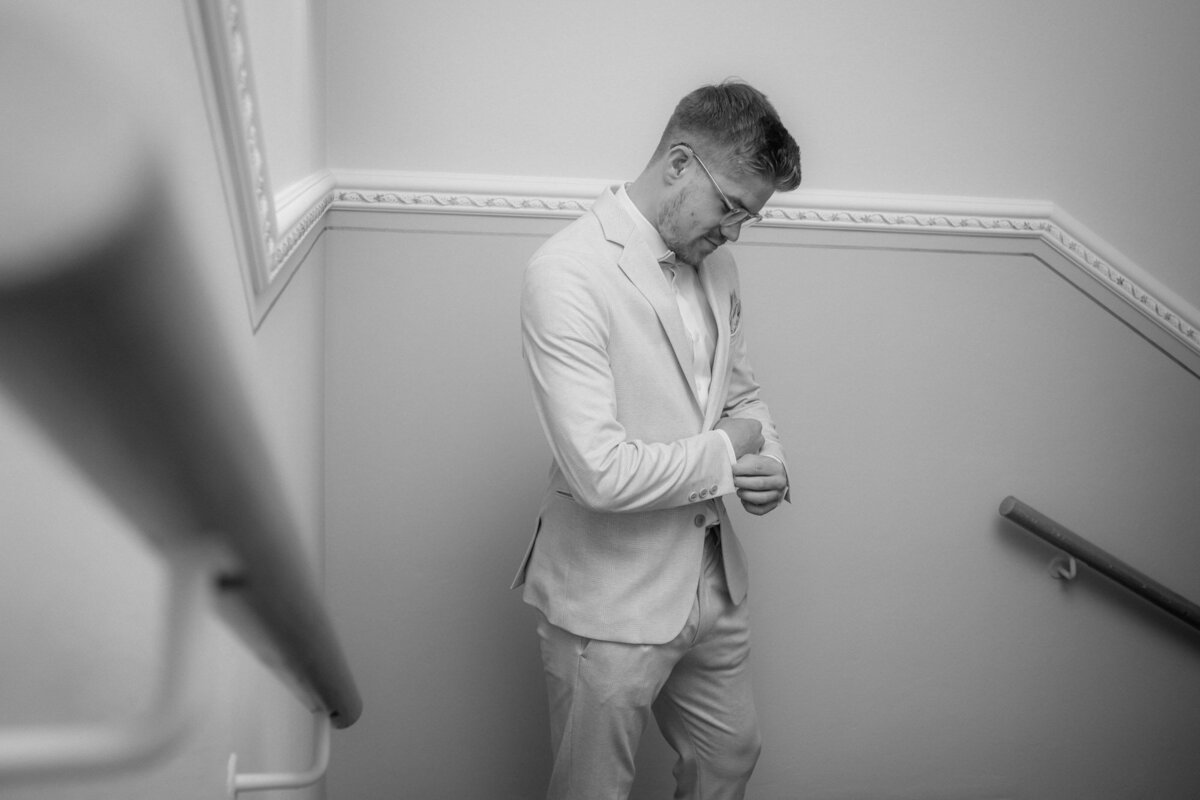 Ready for his big day, the groom awaits his bride in a staircase.