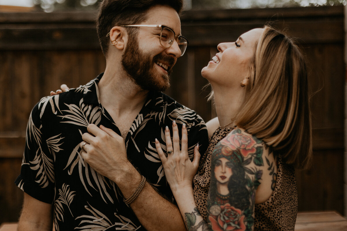 tattooed couple holding each other in southwestern backyard