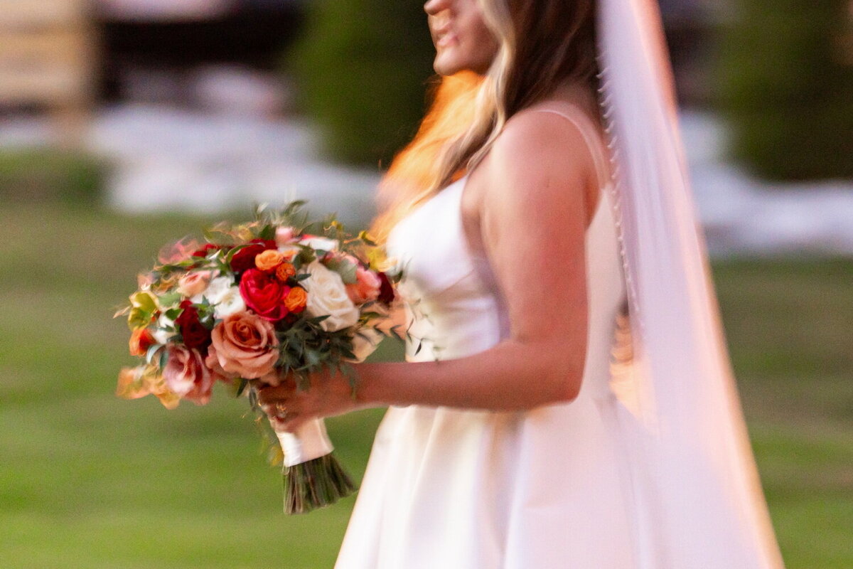 blurry movement image of a bride's bouquet in orange sunlight