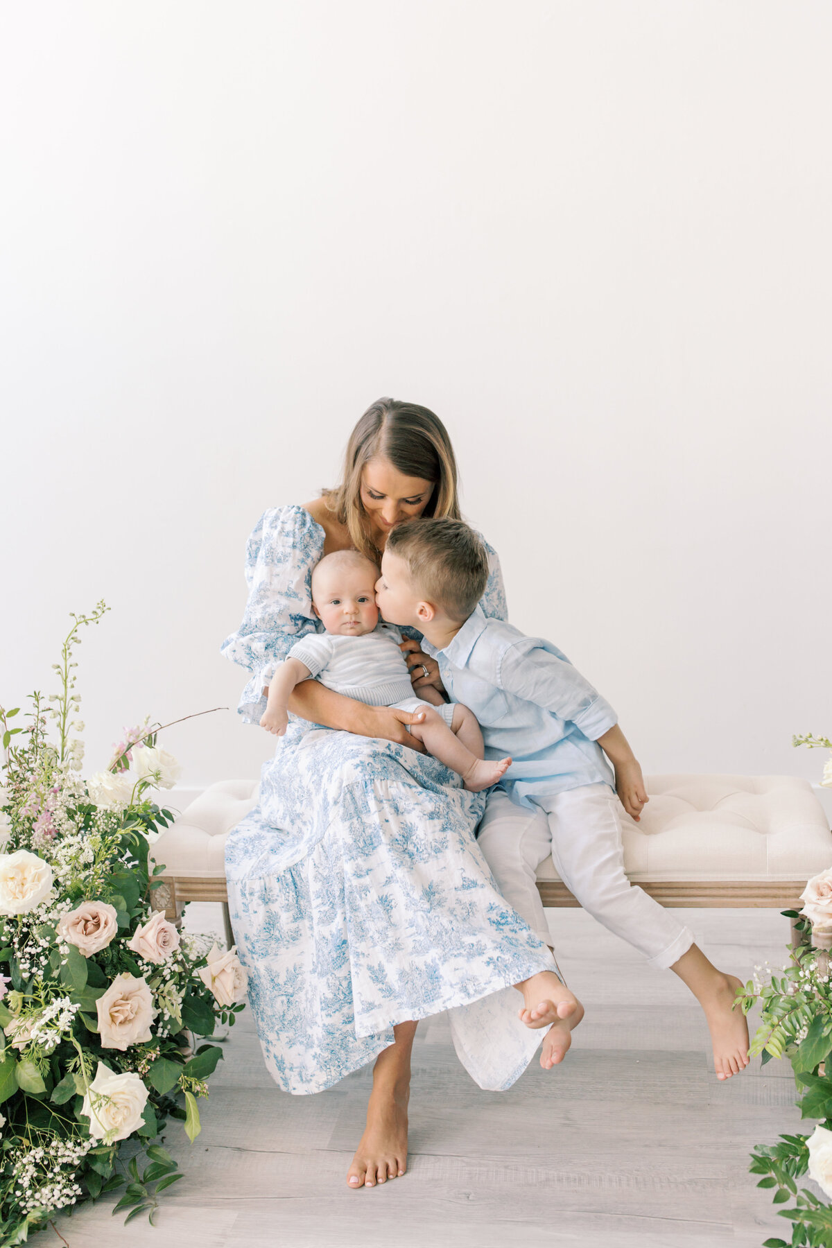 mom with sons in photo studio with floral arrangement by one of the photographers in spokane wa