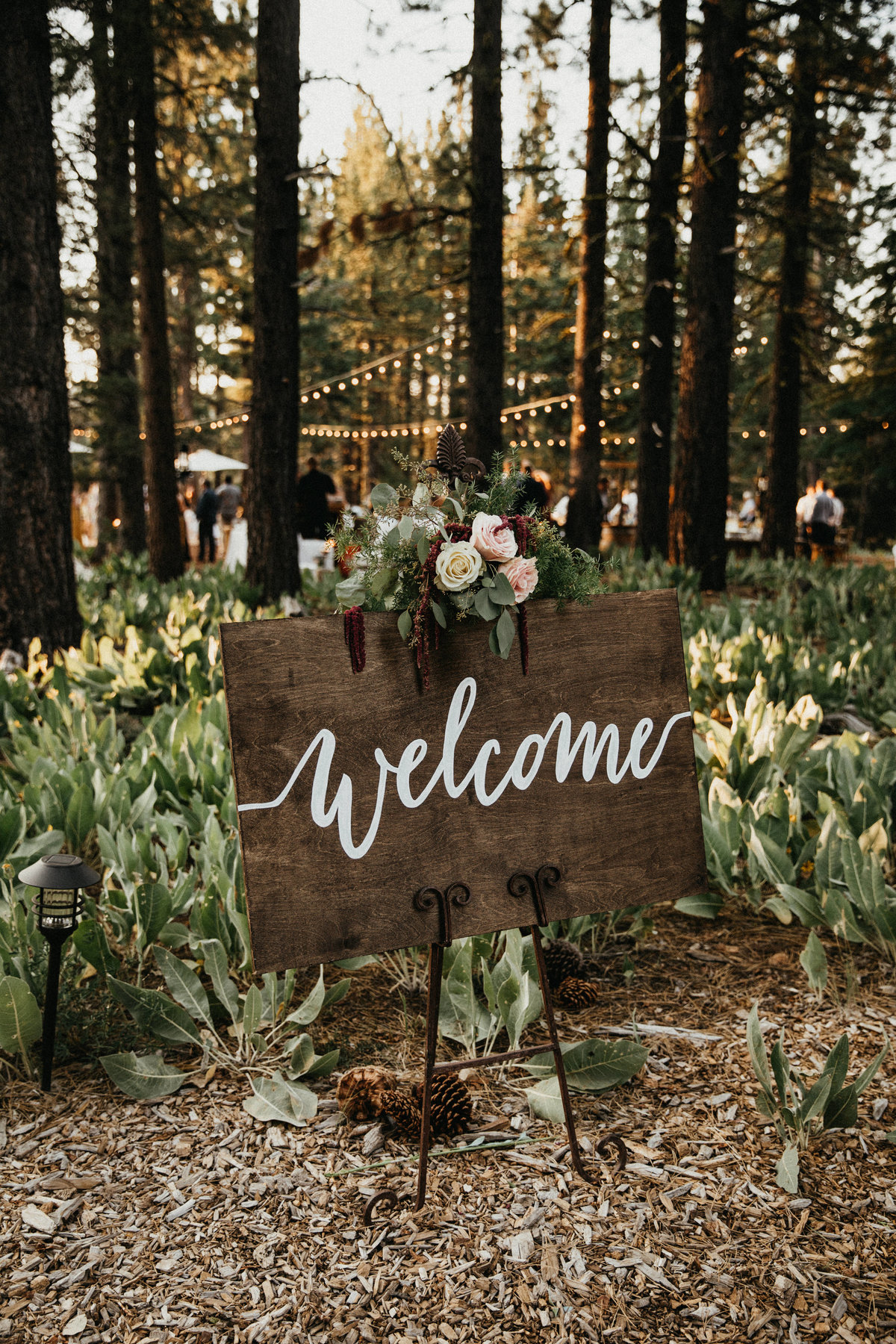 Tahoe Wedding Planners wood welcome sign with floral garland at summer wedding venue Mitchell's Mountain Meadows Sierraville near Truckee, Joy of Life Events image by Lukas Koryn