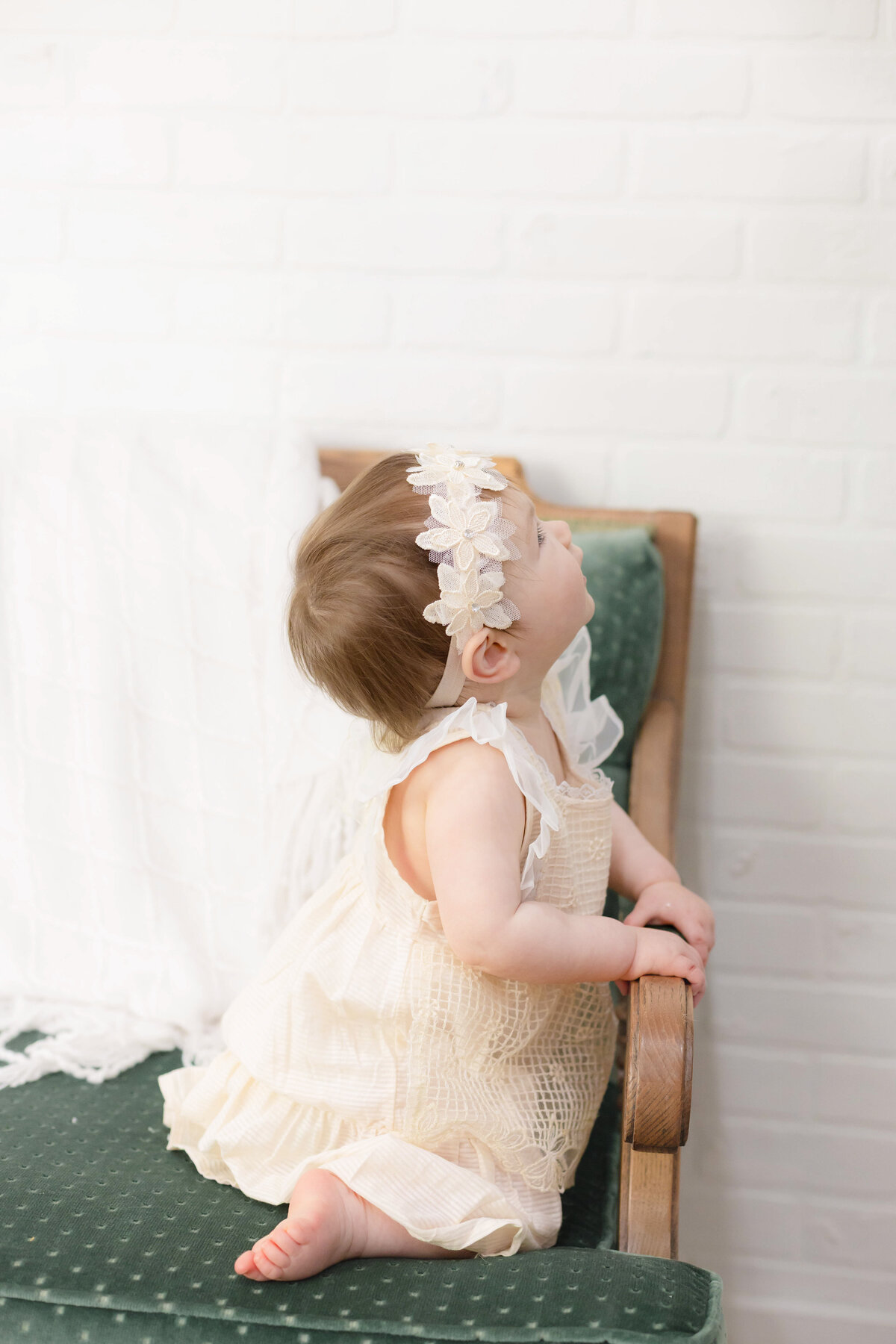 Baby's first birthday milestone by a Provo Utah photographer in a bright, clean studio in Lehi Utah picturing a happy one year old baby girl in a natural state of play and wonder.