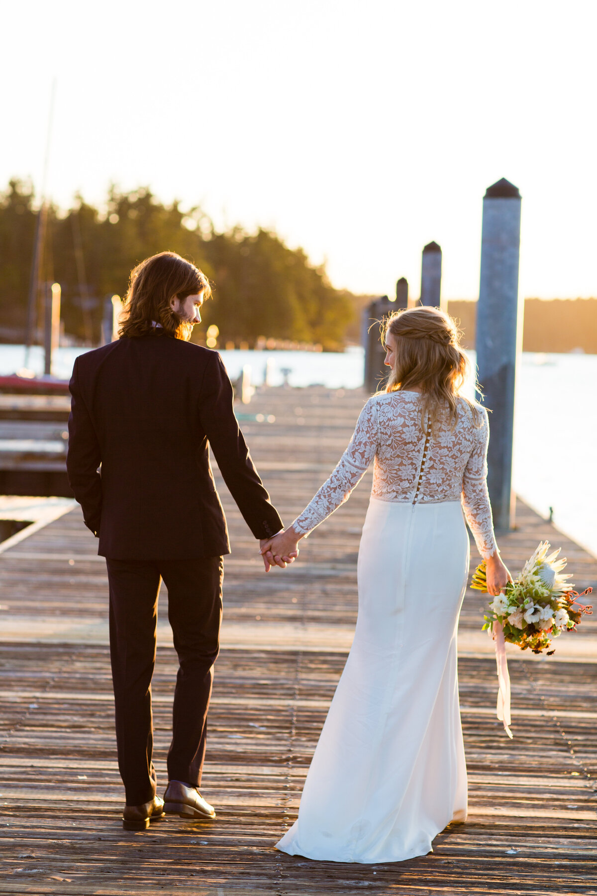 bride-and-groom-walk-dock-at-roche-harbor-photo-by-la-vie-photography