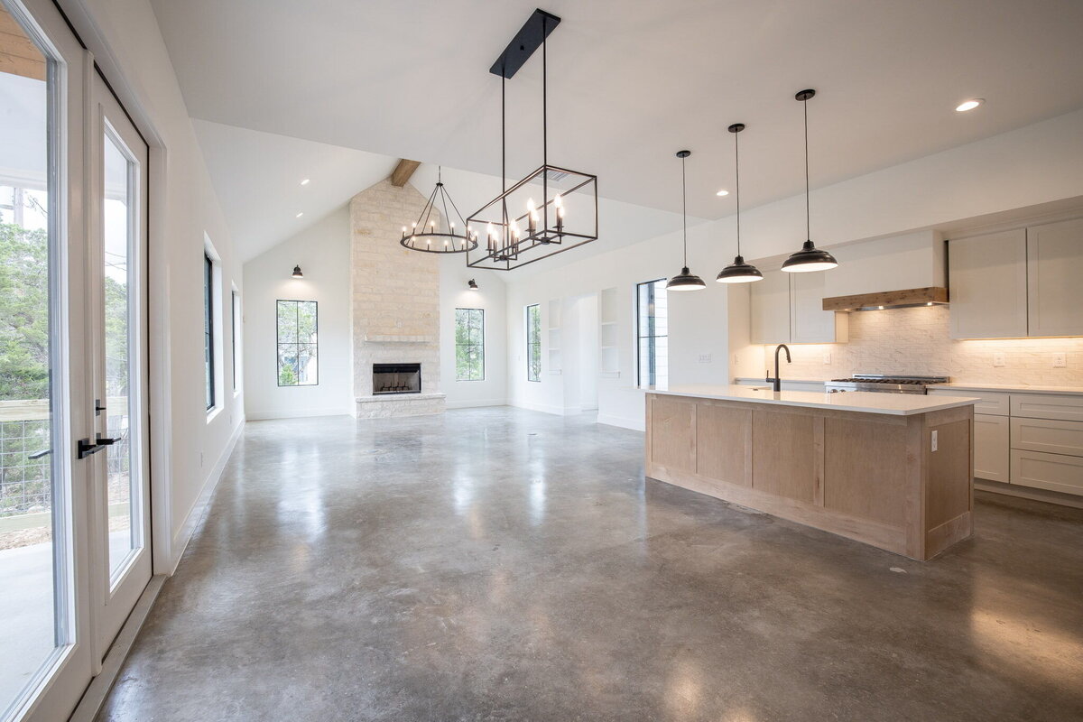 open dining, kitchen and living room with concrete floors