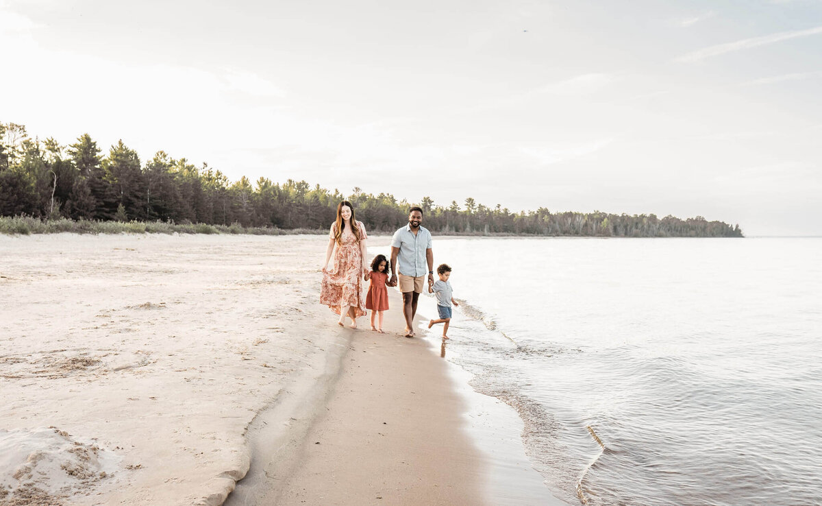 Family walking on a beach with two toddlers