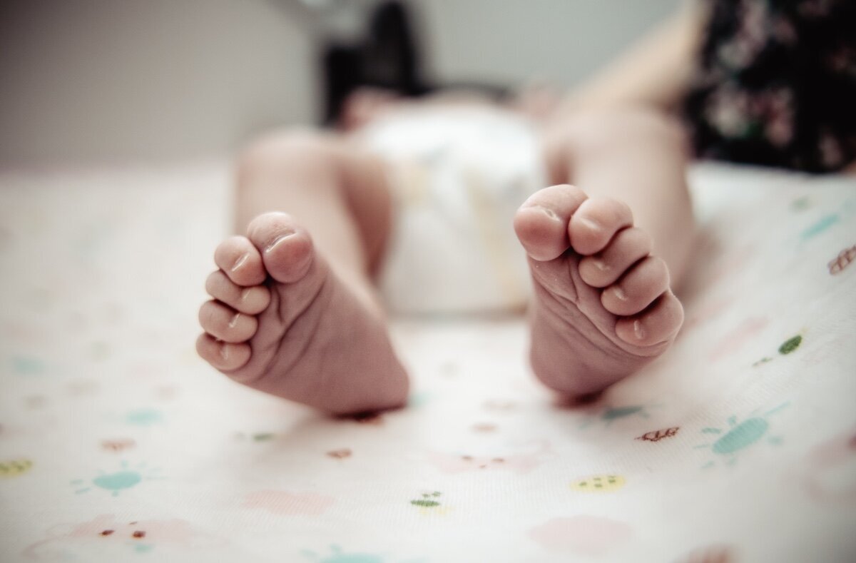 A closeup of a newborn baby girl's tiny feet