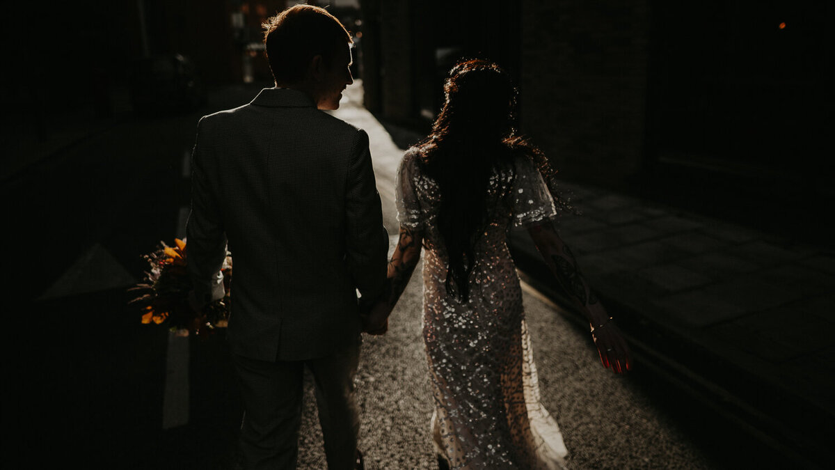 Bride and Groom walk in the evening golden hour light during their wedding portraits in London. 