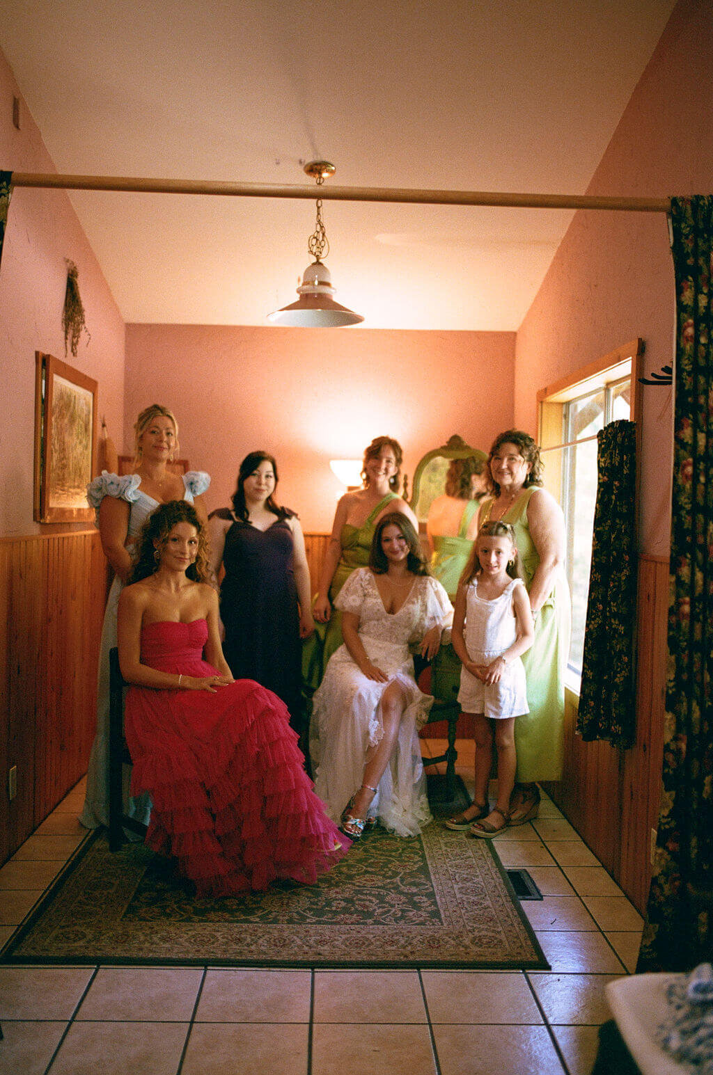 The bride and her bridal party smile at the camera before a vintage garden wedding planned by Birdie June Events.