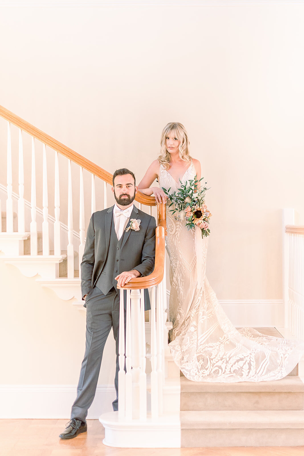 bride and groom pose on staircase in  mansion at flying horse