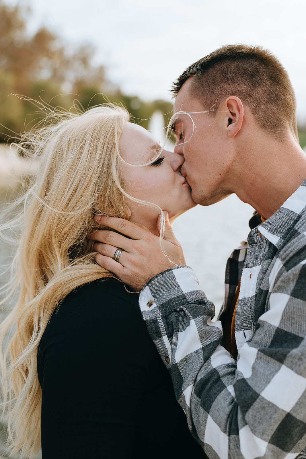 husband and wife kissing as the wind blows