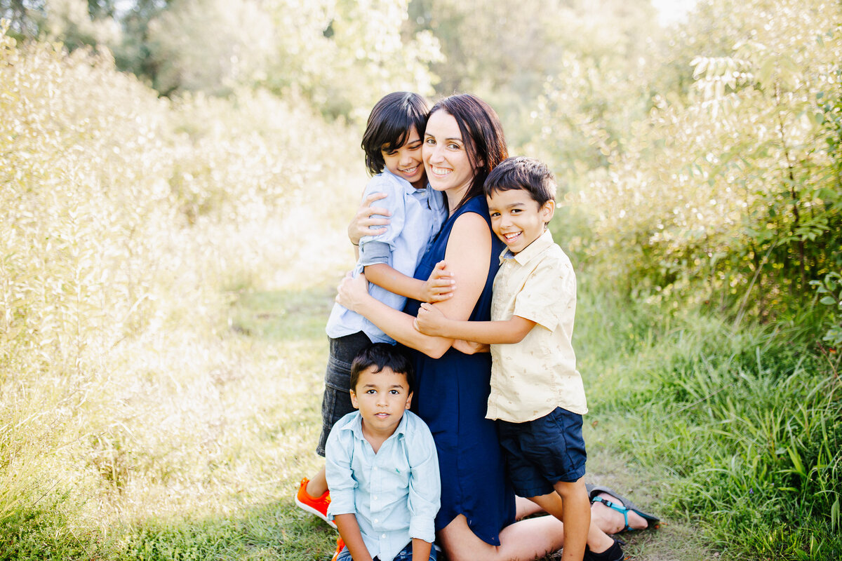 Beautiful mom poses for hugs with her 3 boys