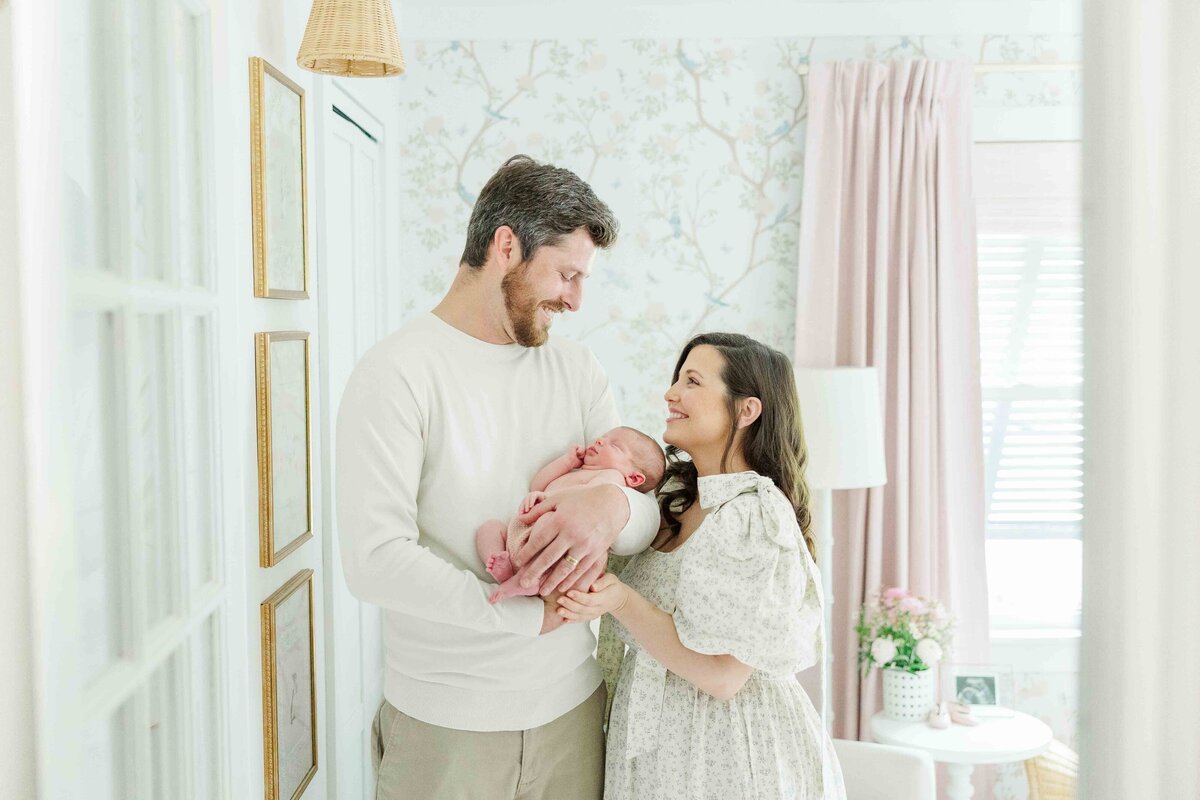 newborn parents holding daughter in nursery in Kinston, NC