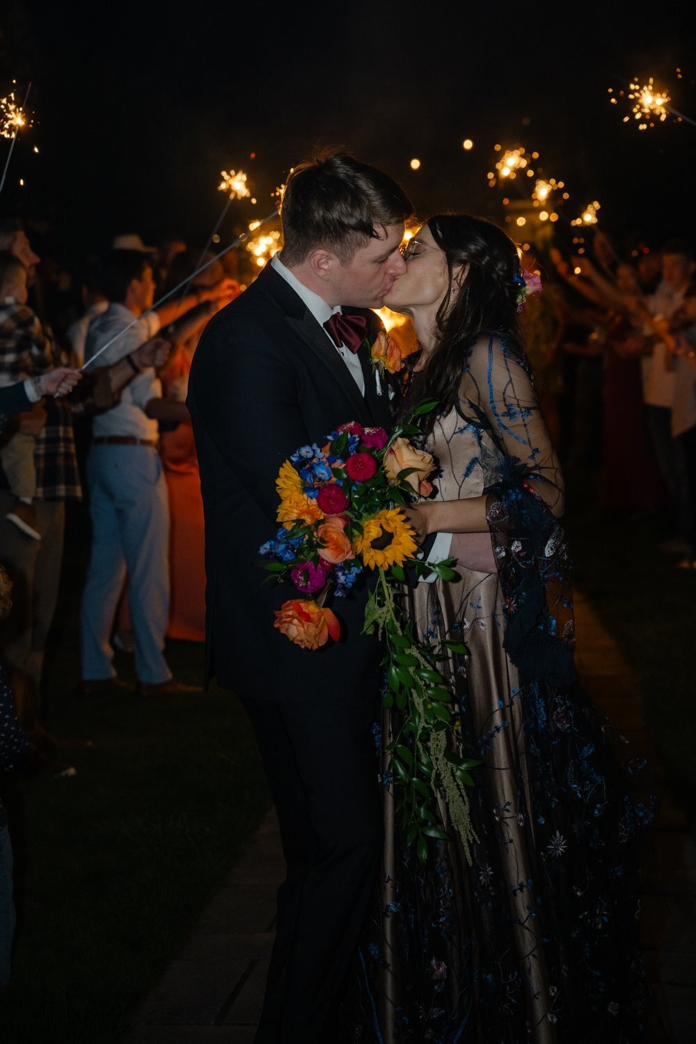 bride and groom leave evergreen meadows wedding venue with sparkler exit and kiss