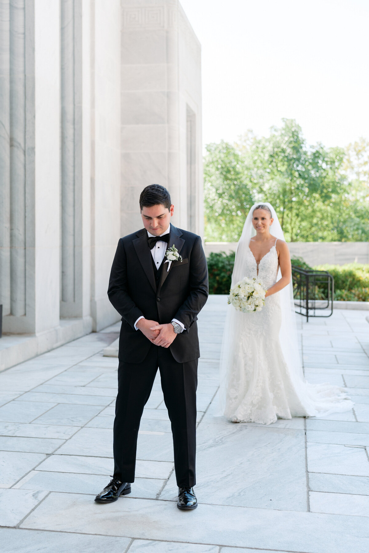 Bride approaches groom for first look outside Philly venue, candidly photographed by a Philadelphia wedding photographer.