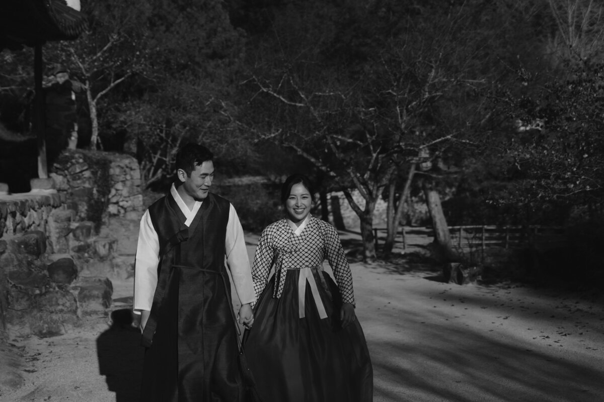 the couple smiling and walking in soswaewon garden