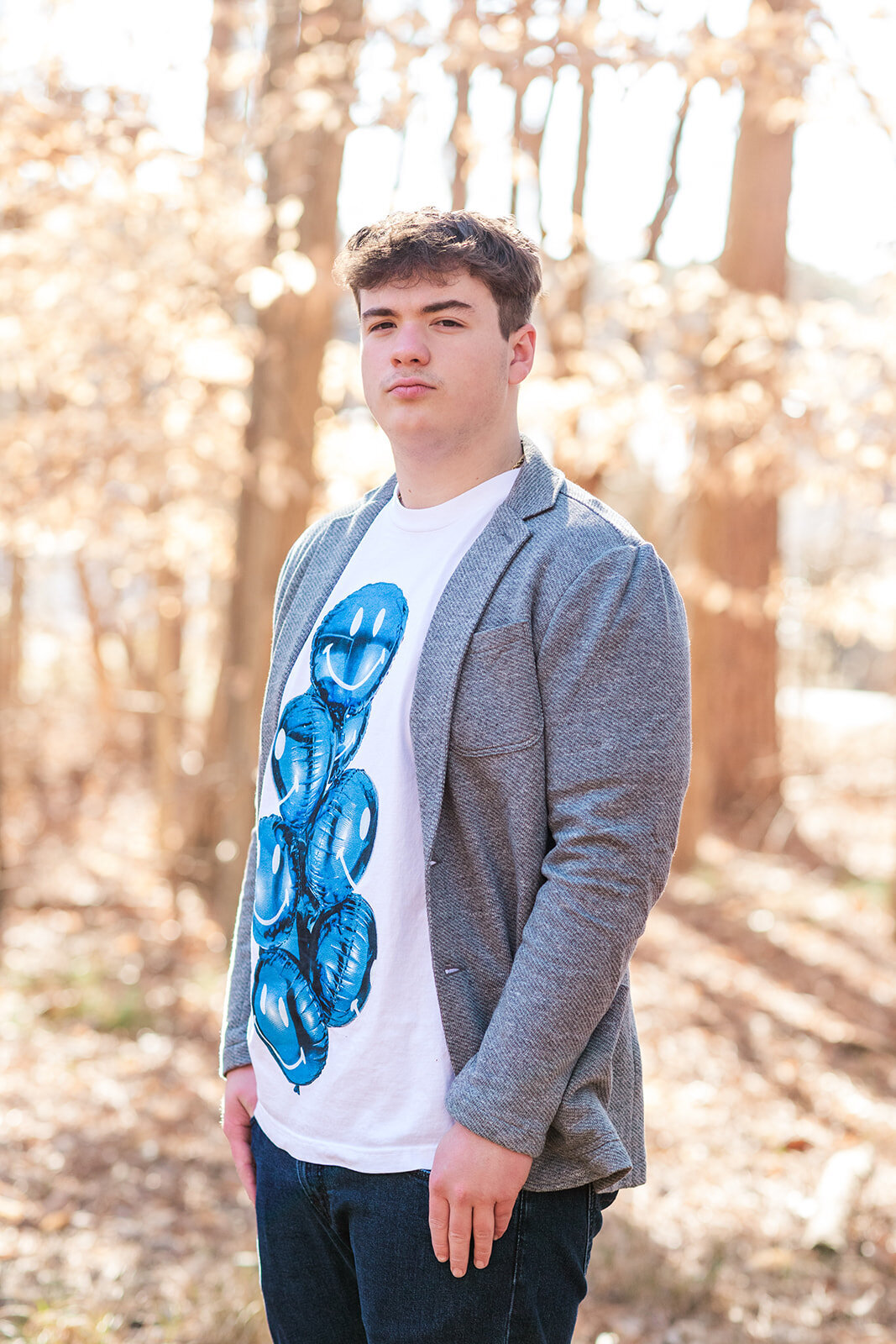 Boy with hands in his pockets during senior session in the woods