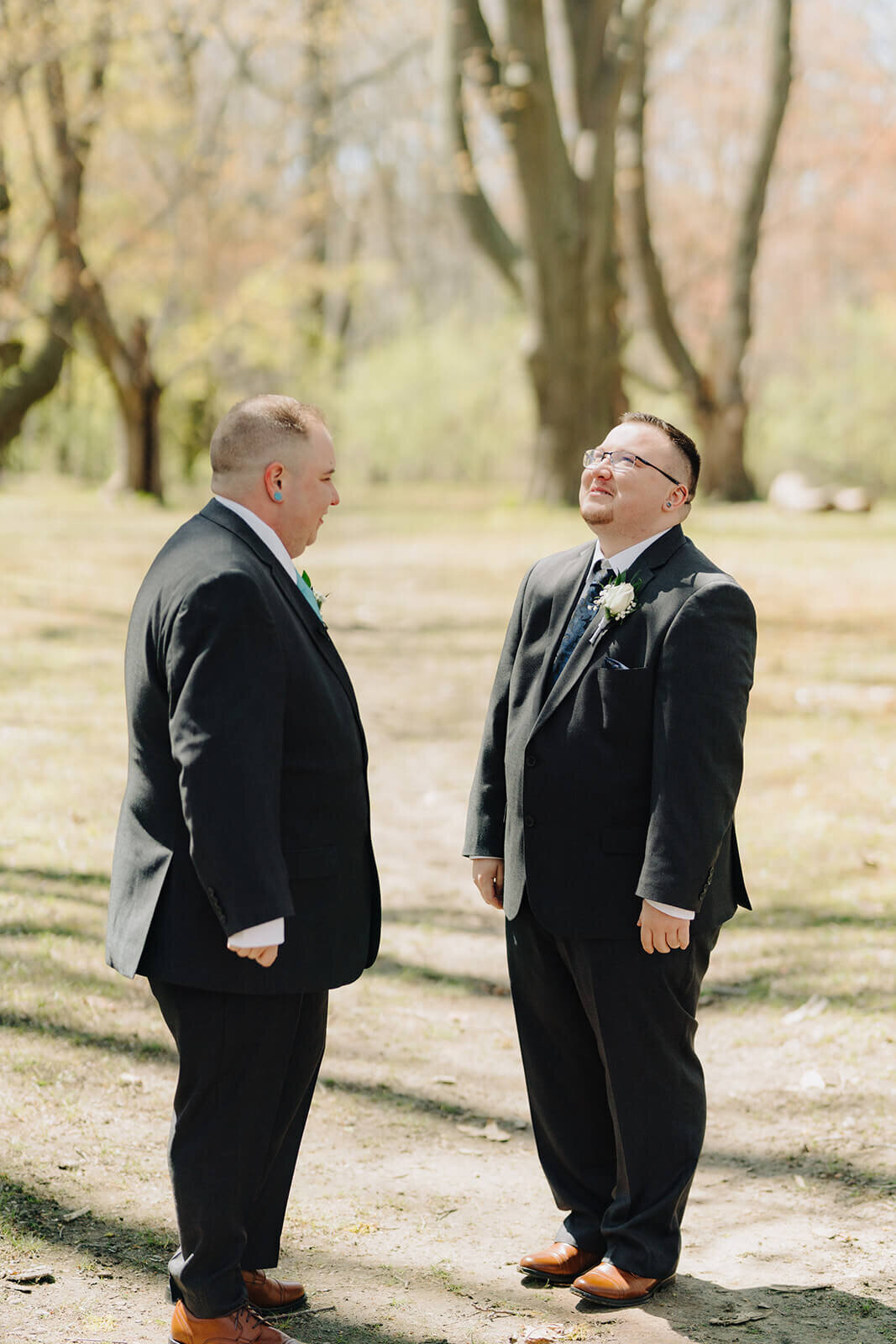 Gay couple looking at each other in forest area in Rochester NY