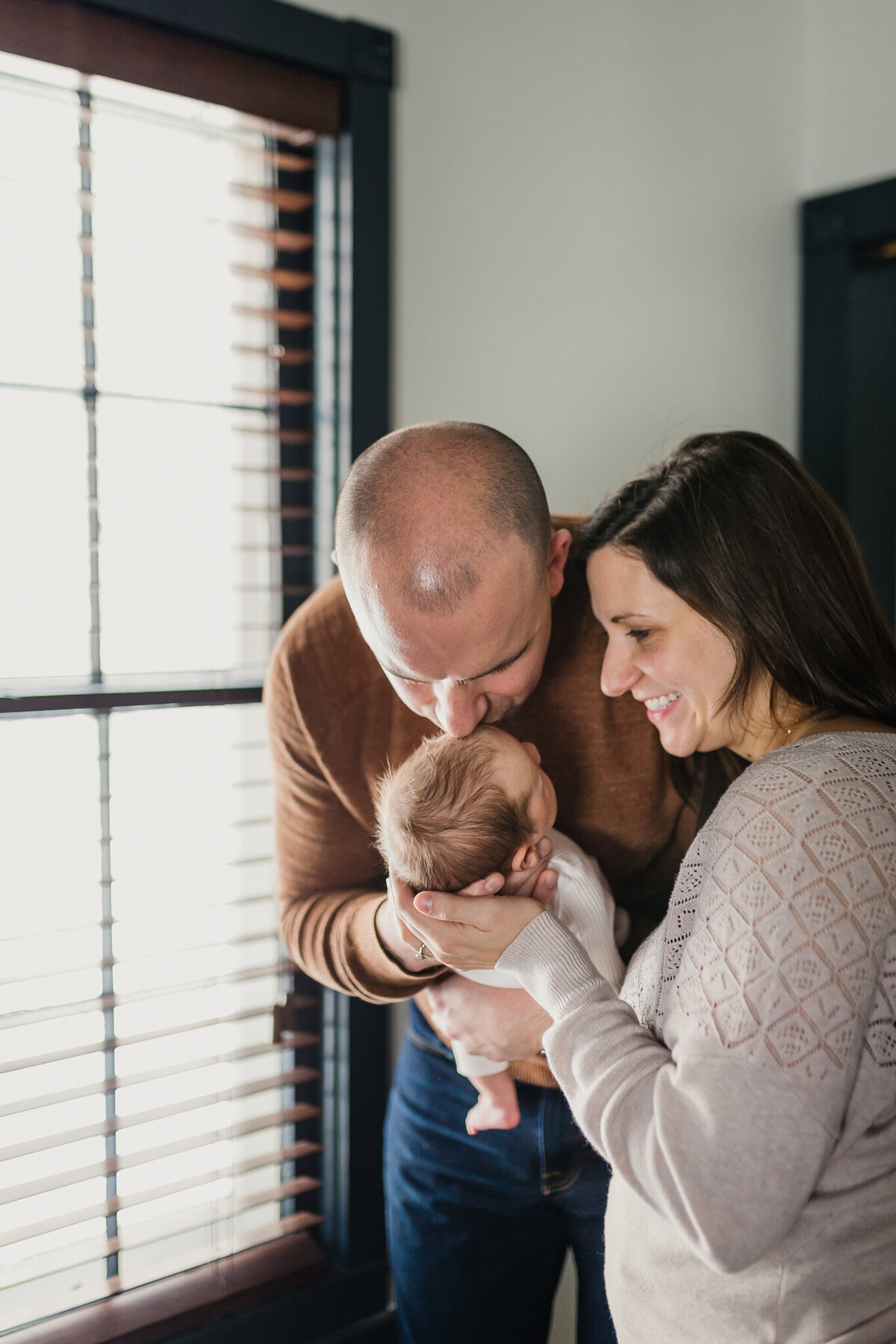 Infant photography of a mom and dad holding baby