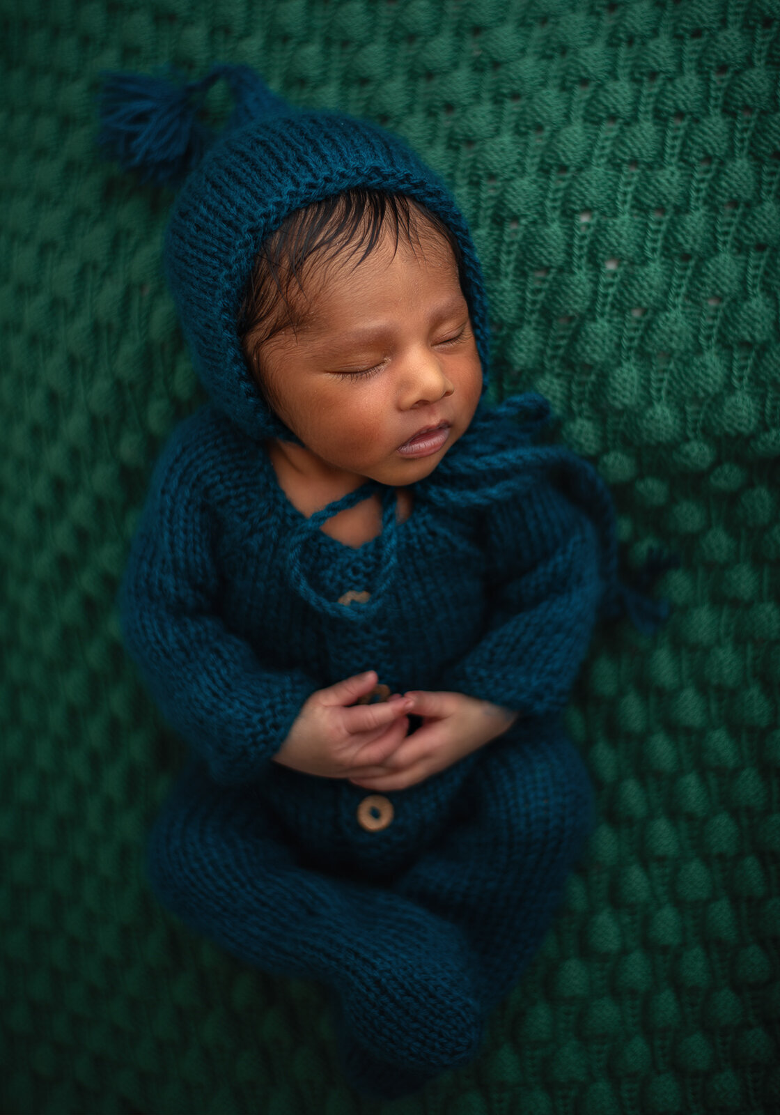 baby sleeping on back with hands folded at st louis newborn photo session
