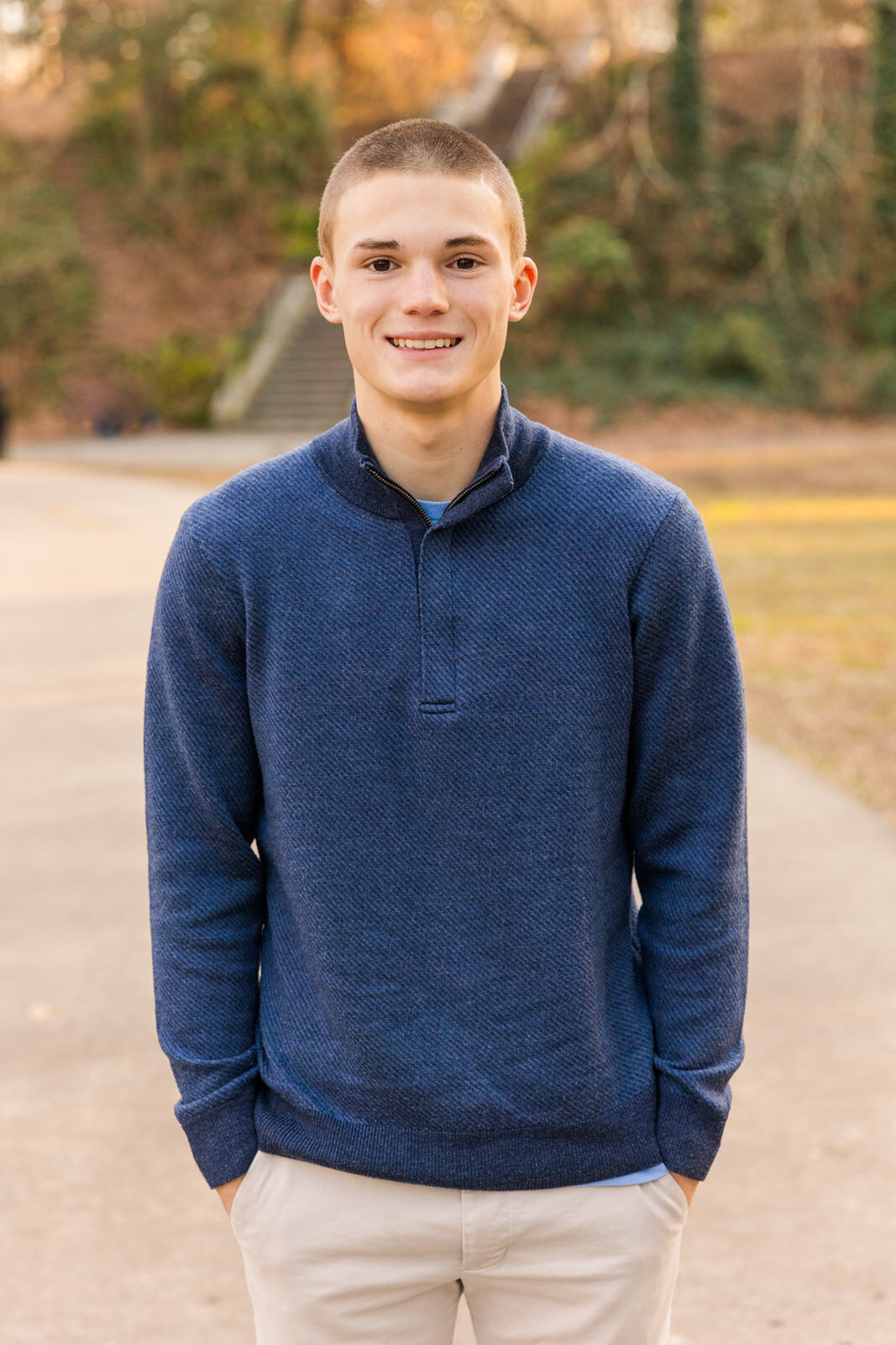 High school senior boy standing in the middle of a park path hands in pockets durong winder senior photo session Atlanta with Laure Photography