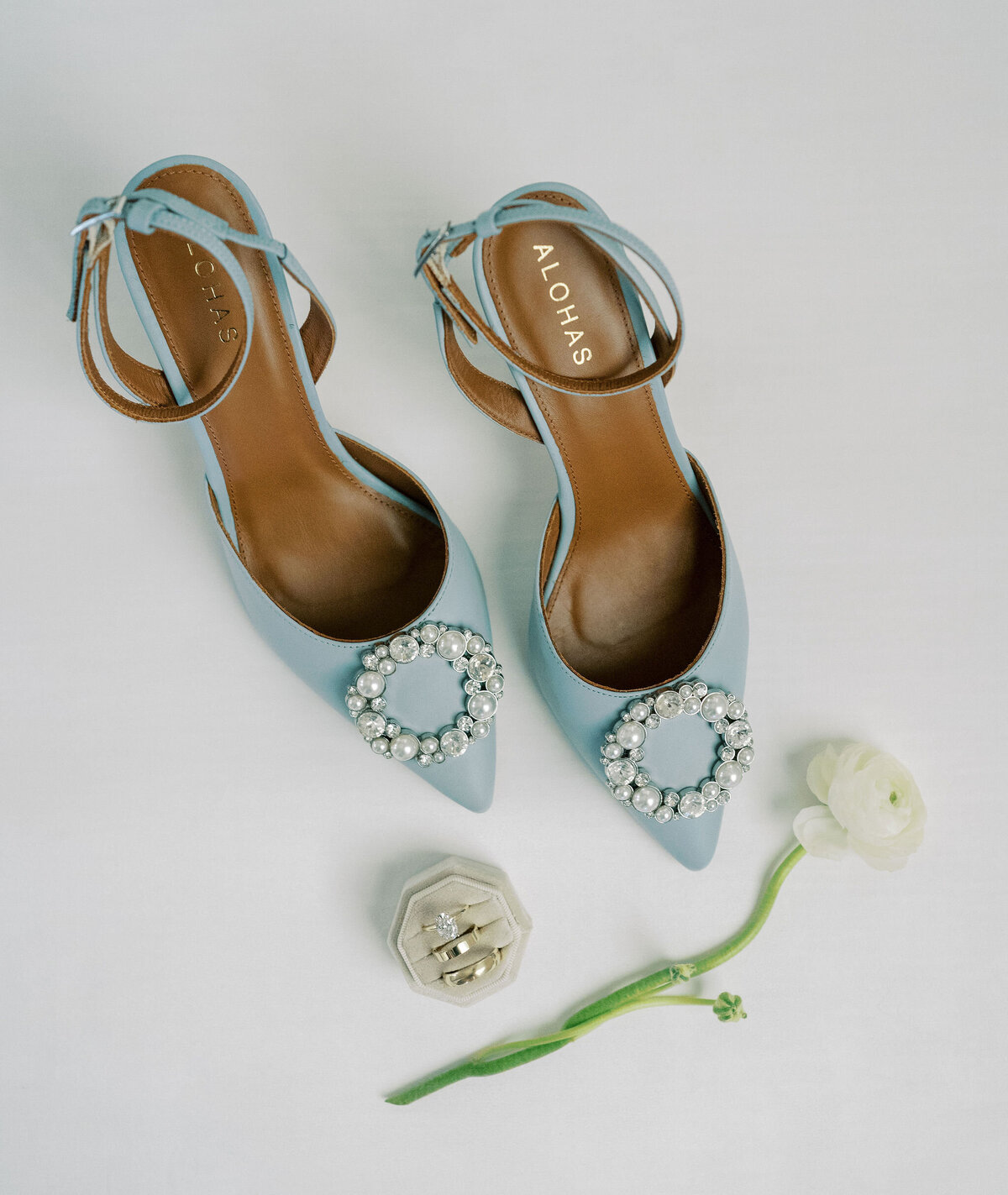 blue bridal shoes, wedding rings, and a flower