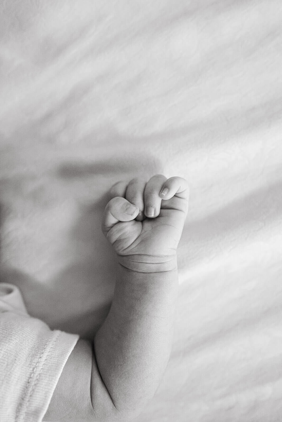 Lifestyle newborn photography in Brentwood CA with parents cuddling baby boy in nursery.