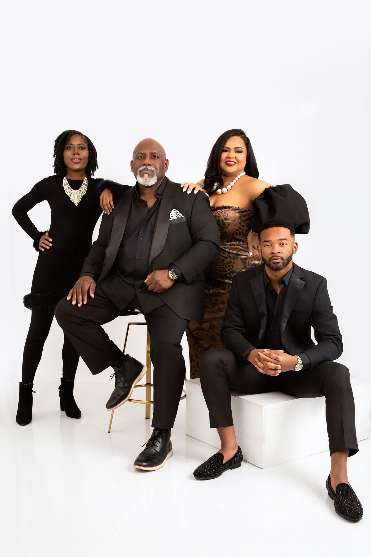 Family in all black formal attire posing for family portrait.