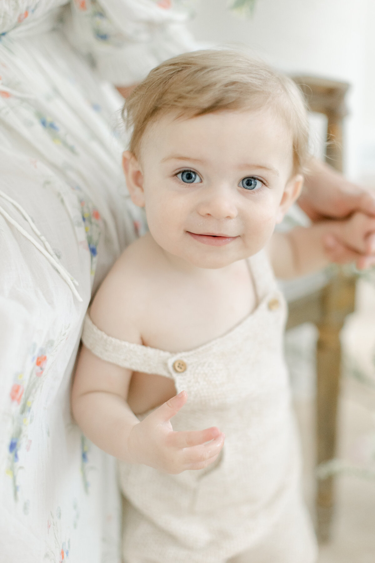 sweet 9 month old boy with bright blue eyes wearing a knit overall set from Philadelphia Portrait Photographer Tara Federico's studio wardrobe