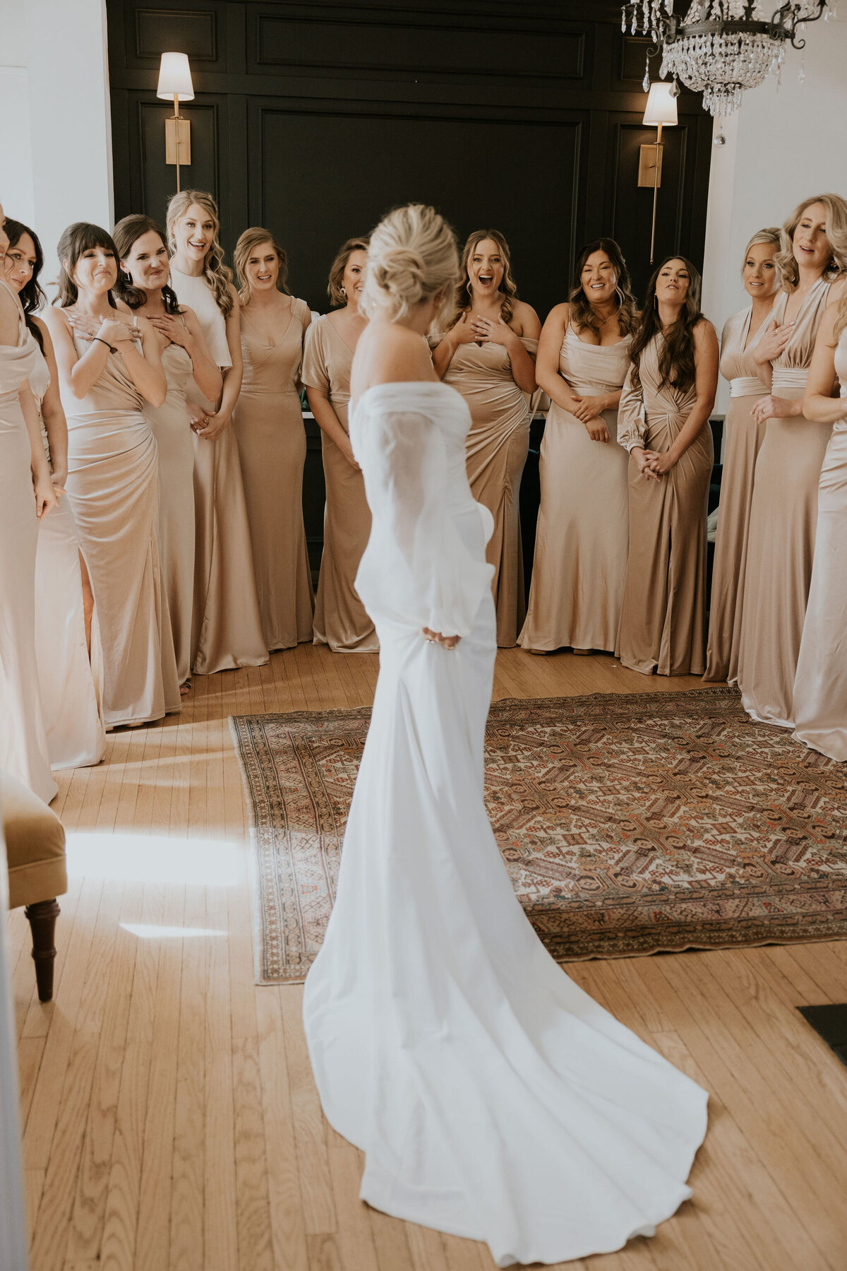 Classic white wedding dress with bridesmaids looking on