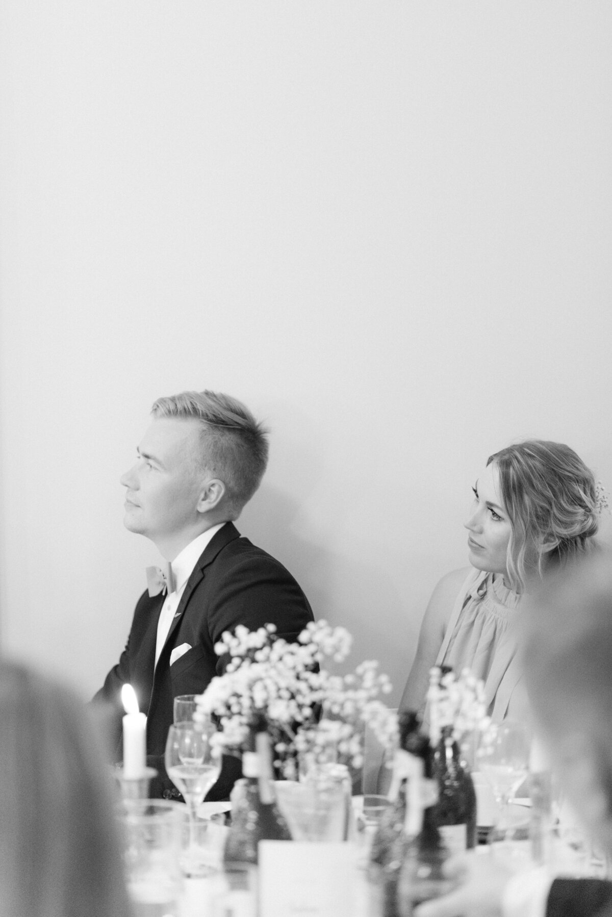 Documentary wedding photograph of wedding guests listening to a speech to bride and groom in Airisniemi manor in Turku, Finland. Atmosphere captured by wedding photographer Hannika Gabrielsson.
