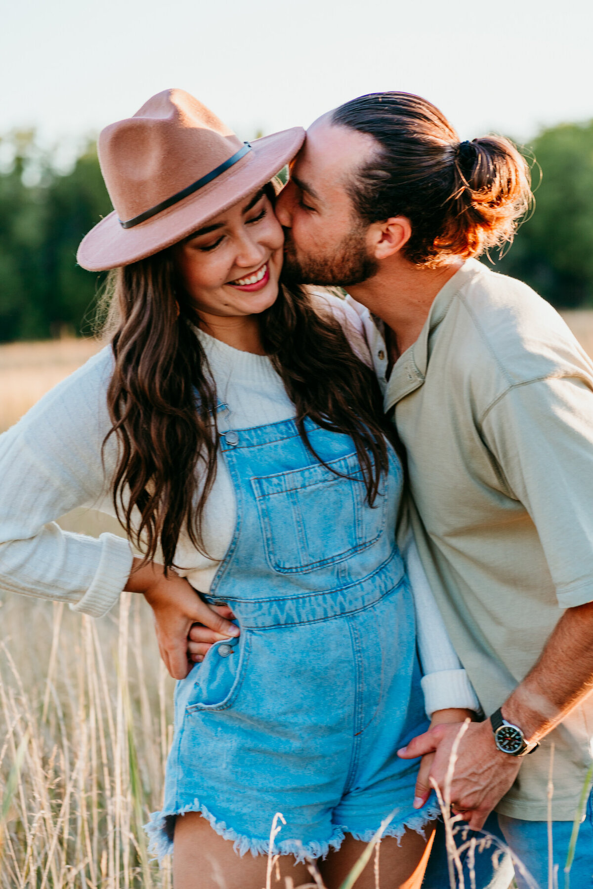 Couple snuggling and smiling during a cozy outdoor shoot