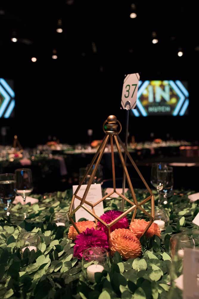 Seattle fundraiser centerpiece with orange and pink dahlias in gold geo shaped lantern