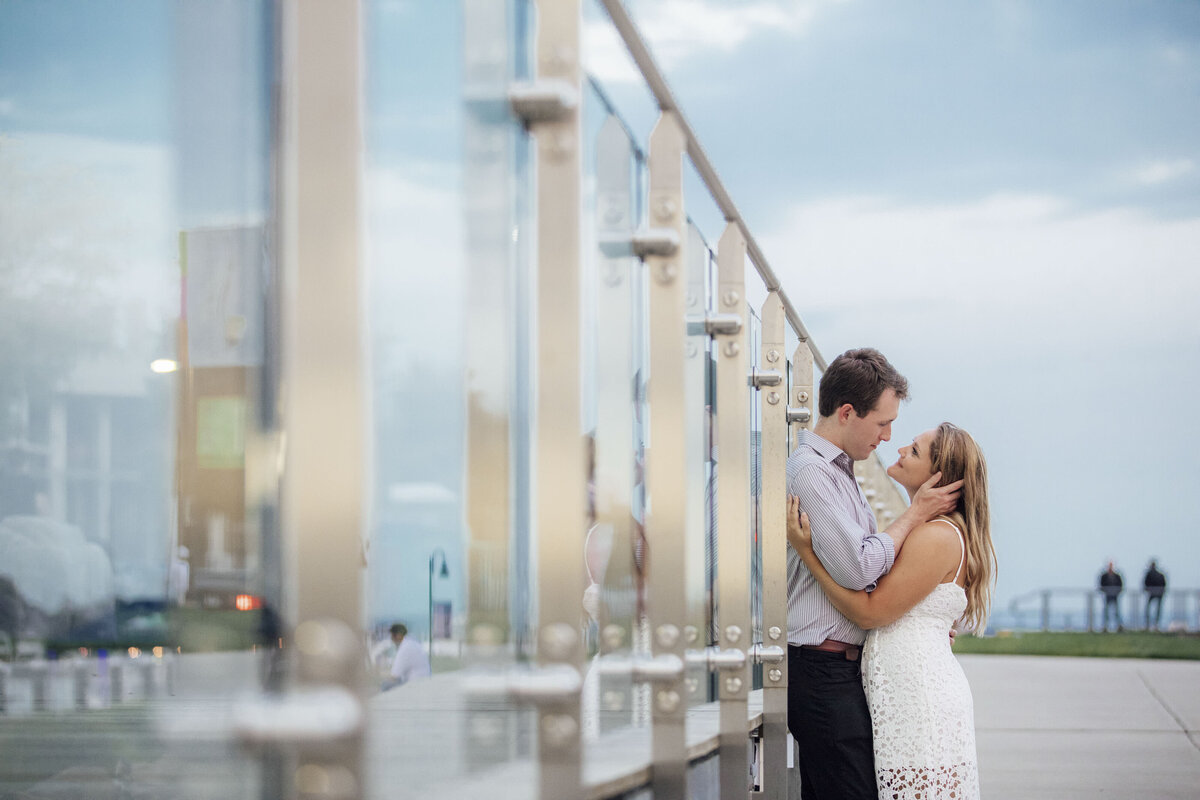 Couple in romantic pose by glass wall during engagement session in Connecticut