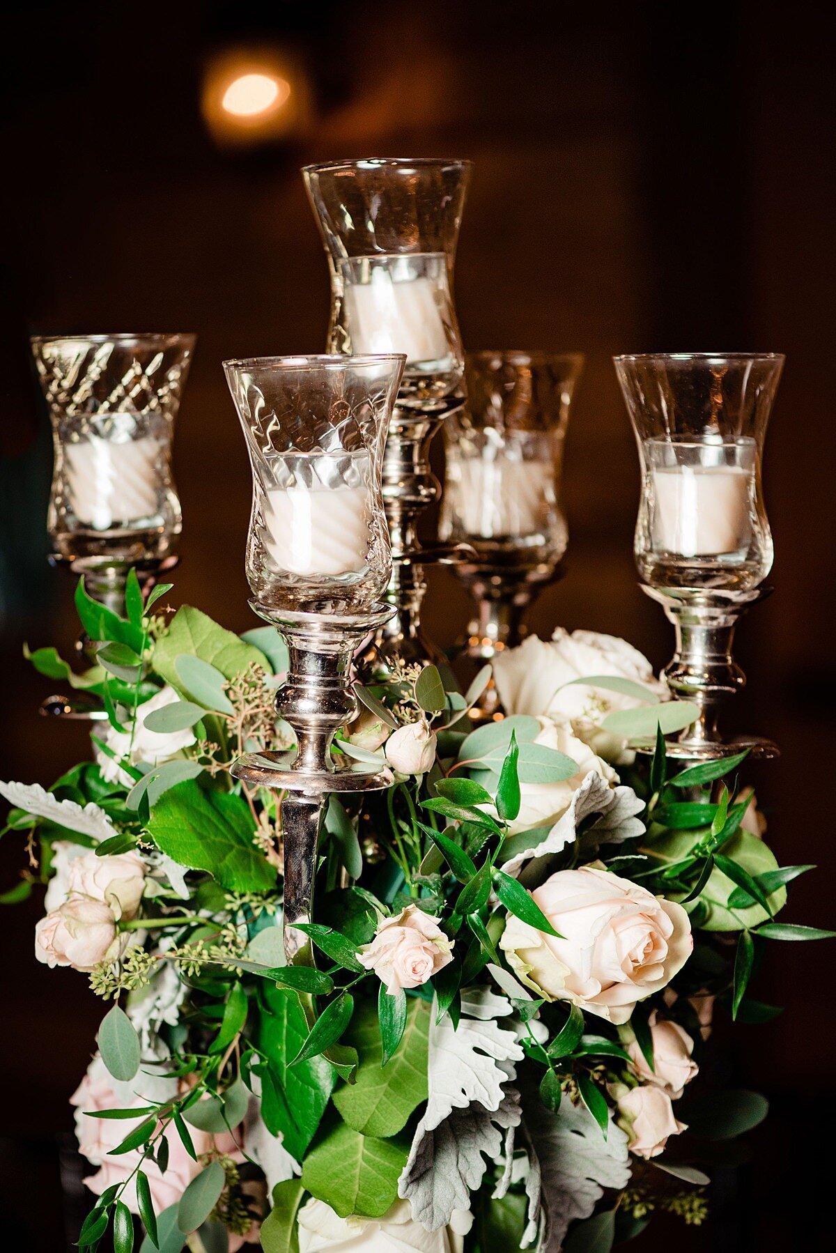 Silver candelabra wedding centerpiece with white and ivory roses and greenery