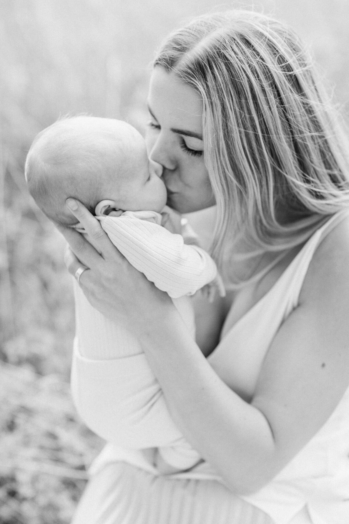 En mamma ger sin bebis en puss på munnen