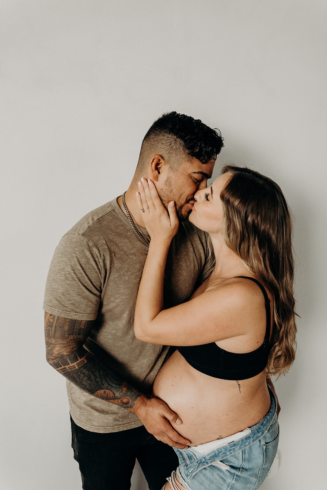 kissing couples maternity photo with tattoos
