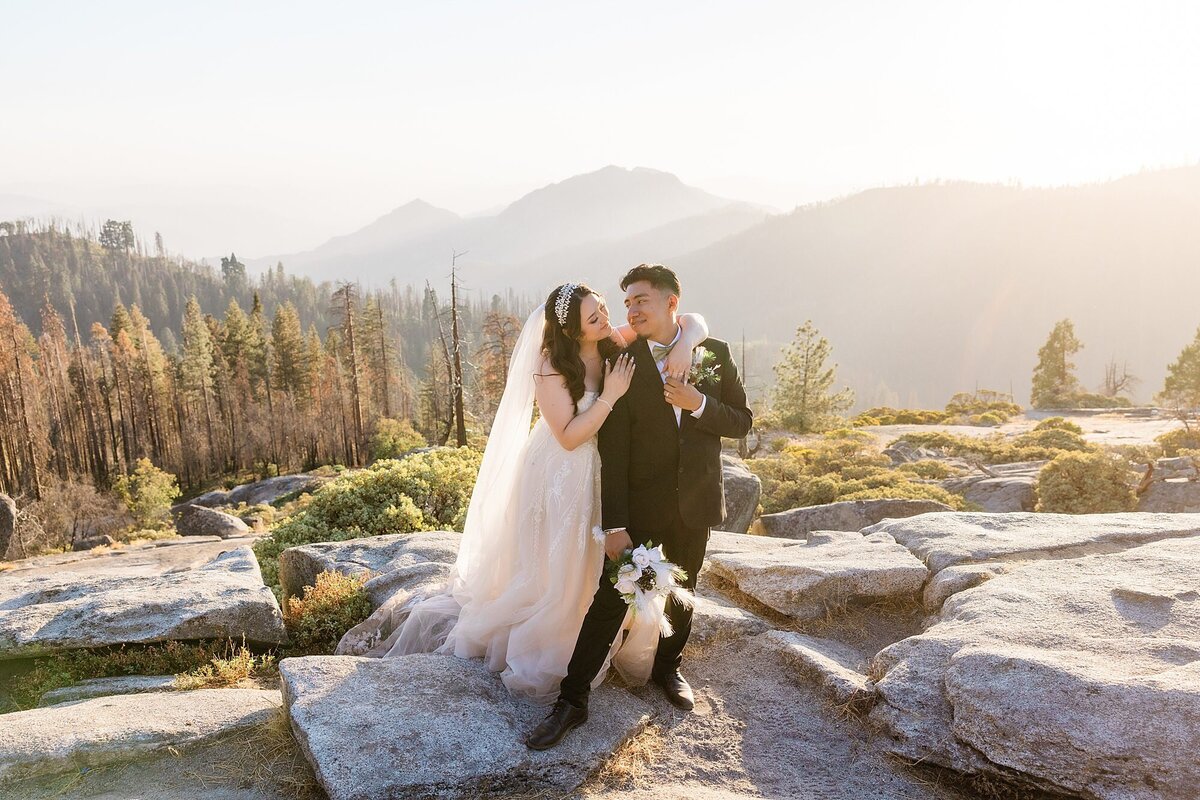The bride and groom stand on Beetle Rock in Sequoia National Park during their bride and groom wedding photos.