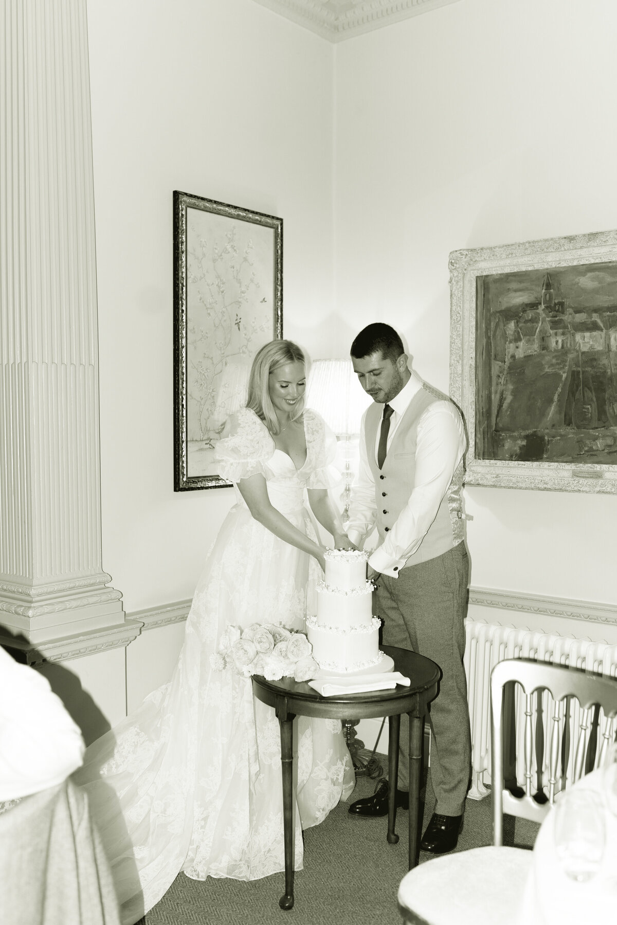 Black and white editorial flash wedding photography by Jill Cherry Porter of Bride and Groom cutting their cake in Cromlix House Scotland.