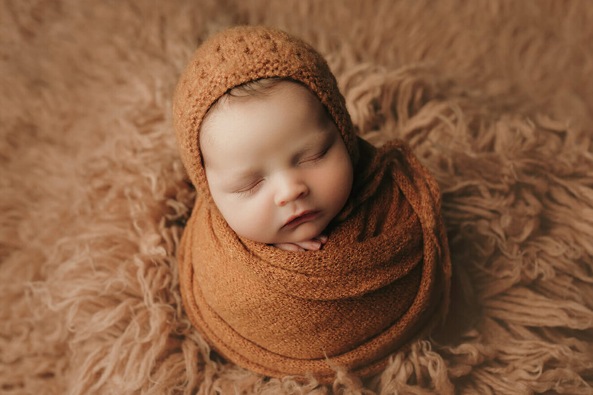 boy sleeping wrapped up in brown setup